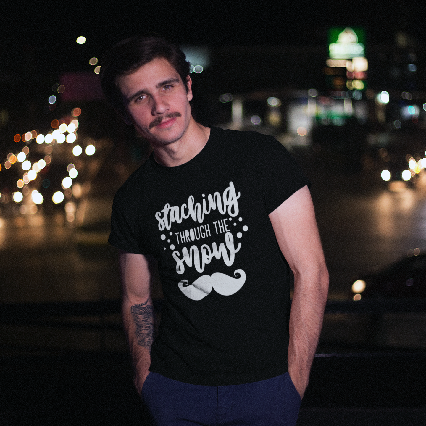 Man with mustache wearing black shirt with 'Staching through the snow' print by KMLeon.