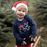 Happy blonde girl with christmas hat, wearing navy shirt with long sleeves with dino 'Fla La La Rawr Rawr Rawr' print by KMLeon.