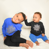 Black brothers wearing shirts with long sleeves with glitter snow star print by KMLeon, touching other ones hair.