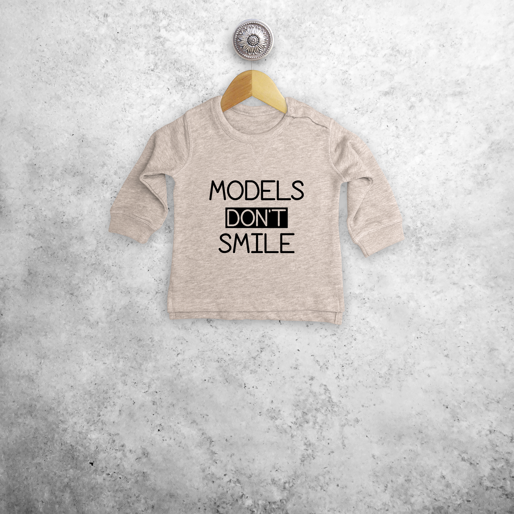 'Models don't smile' baby sweater